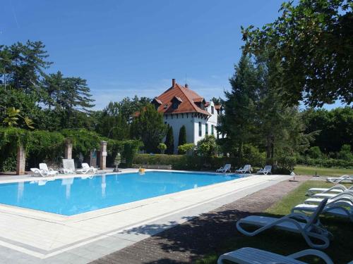 a swimming pool in front of a house at Apartments in Balatonudvari 45330 in Balatonudvari