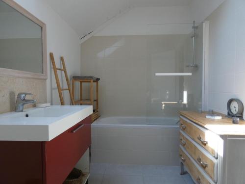 ein Badezimmer mit einem Waschbecken und einer Badewanne in der Unterkunft Gîte Beaumont-les-Autels, 3 pièces, 6 personnes - FR-1-581-104 in Beaumont-les-Autels