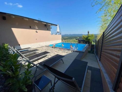 un patio con sillas y una piscina en Holiday house with a swimming pool Novi Marof, Medimurje - 21983 en Novi Marof