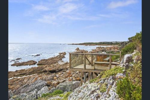 a wooden platform on the side of a rocky beach at Heathcliff. Stunning ocean views! in Boat Harbour