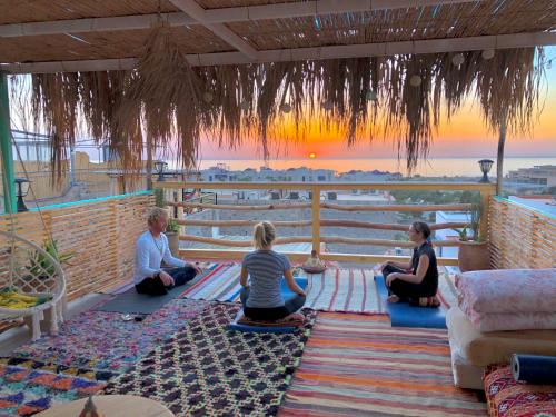 a group of people sitting on the floor in meditation at Natural Surf House in Tamraght Ouzdar