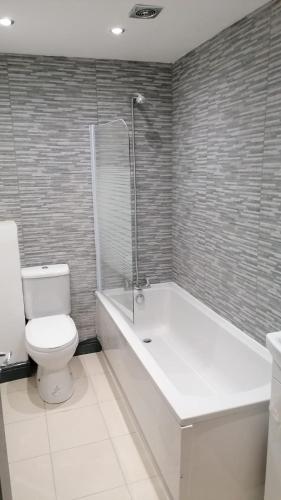 a bathroom with a toilet and a tub and a sink at St Marks Lodge Clacton-On-Sea in Shotley Gate