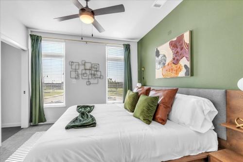een slaapkamer met een groot wit bed en een plafondventilator bij Kingpoolgymbbqfitnessdog Parkgame Room in Rogers