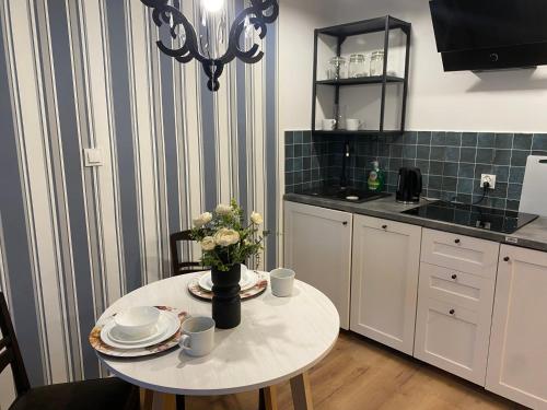 a kitchen with a table with a vase of flowers on it at Tabago Studio 13 in Kędzierzyn-Koźle