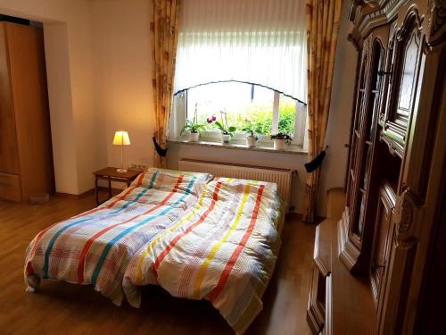 1 cama en un dormitorio con ventana y 1 cama sidx sidx sidx sidx en Apartment in Bissendorf near Osnabrück, en Bissendorf