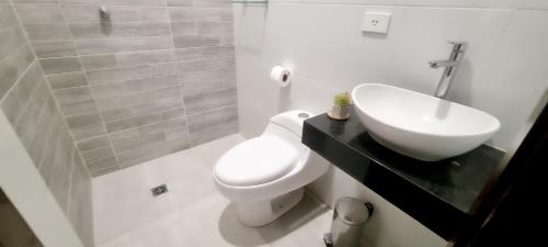 a bathroom with a white toilet and a sink at Suite Posada Express with Free Airport Shuttle in Santa Cruz de la Sierra