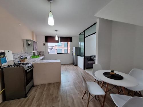 eine Küche und ein Wohnzimmer mit Tisch und Stühlen in der Unterkunft Grande departamento cerca al Shopping y con garage in Santo Domingo de los Colorados