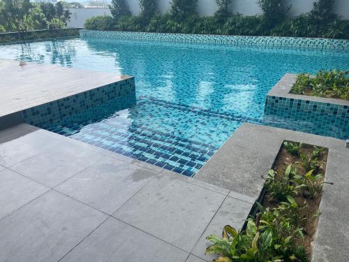 uma grande piscina com azulejos azuis no chão em Neu Suites @3rdNvenue Ampang em Kuala Lumpur