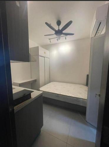 um quarto branco com uma ventoinha de tecto e uma cama em Neu Suites @3rdNvenue Ampang em Kuala Lumpur