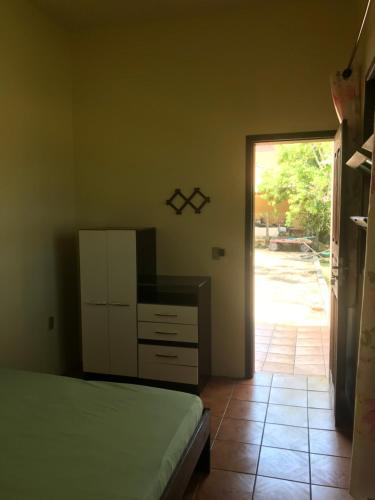 a bedroom with a bed and a door to a yard at Suítes Casa Amarela da Ferrugem in Garopaba