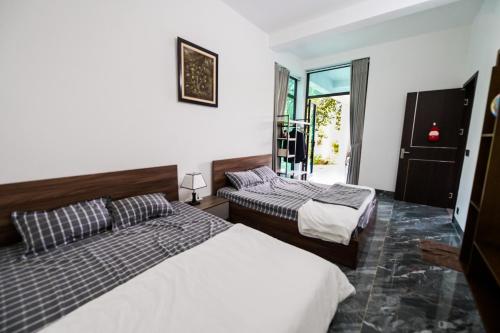 a bedroom with two beds and a window at Dream Hill Villa - Biệt thự trên đồi full tiện ích dịch vụ, ăn uống, tổ chức event in Hanoi