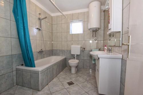 y baño con bañera, aseo y lavamanos. en Apartments with a parking space Kampor, Rab - 17873, en Rab