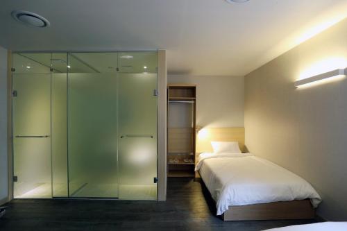 1 dormitorio con 2 camas y ducha de cristal en Hotel 8 Hours, en Seúl