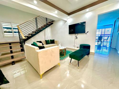 a living room with a couch and a staircase at Modern Oasis By The Waves. in Santa Cruz de Barahona