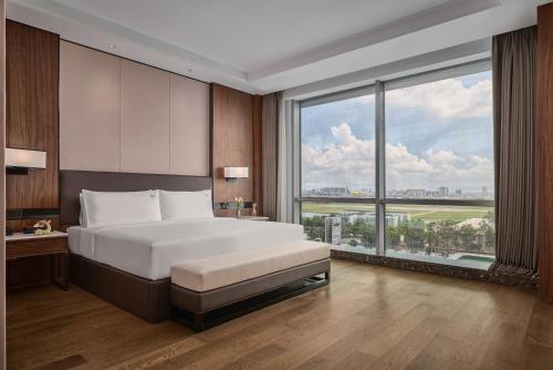 a bedroom with a large bed and a large window at VM Hotel in Phnom Penh