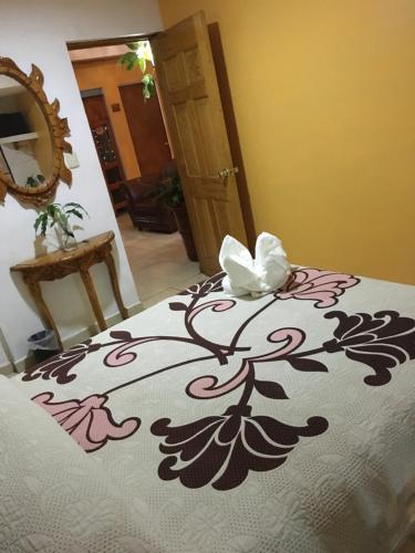 Hotel Posada Camelinas في باتزكوارو: سرير يعلوه زهرة بيضاء