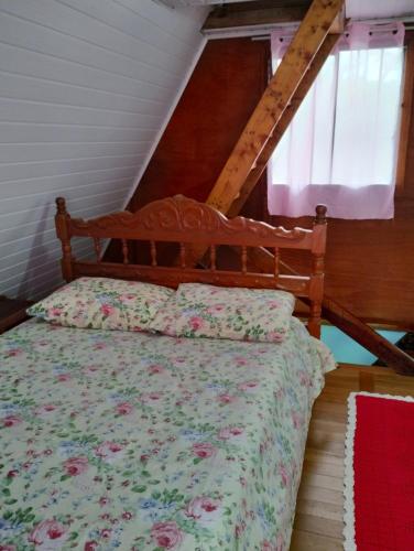 um quarto com uma cama com um edredão floral em Pousada Recanto do Beija Flor em São José dos Pinhais