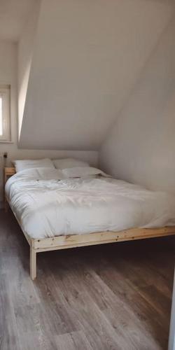 Ce lit se trouve dans une chambre dotée d'un cadre en bois. dans l'établissement maison avec jardinet, à Cuincy