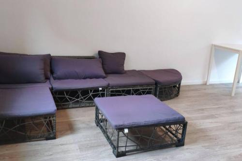 - un salon avec des canapés violets et une table dans l'établissement maison avec jardinet, à Cuincy