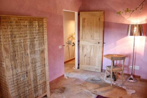 Zimmer mit einer Tür, einem Tisch und einer Lampe in der Unterkunft Country House La Torre in Tuscania
