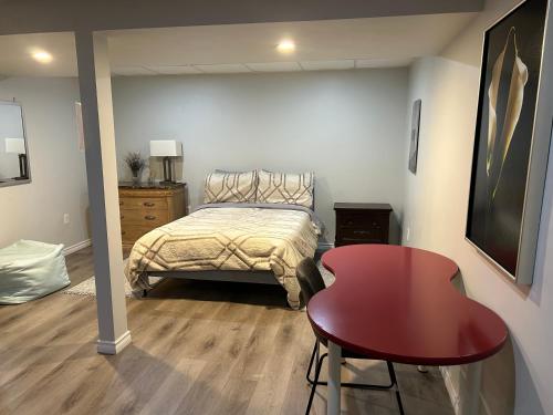 a bedroom with a bed and a red table at A Bright Specious 1 Bedroom Unit in the Basement in Ottawa