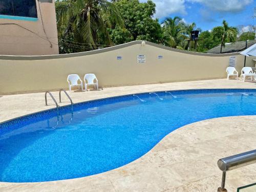 una gran piscina con sillas junto a un edificio en Cabaña Arrecife 07, en Coveñas