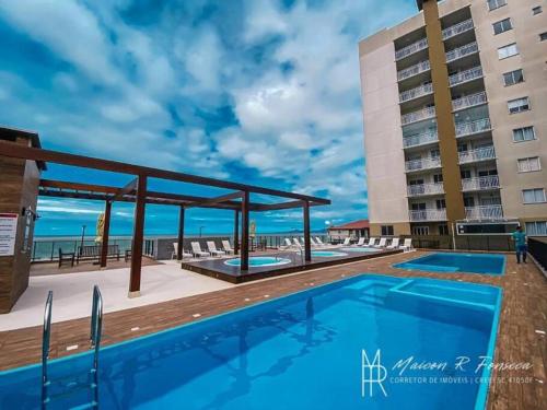 ein Swimmingpool mit Blick auf das Meer in der Unterkunft Apê pé na areia com vista mar e próximo ao Beto Carrero - Condomínio Vila Açoriana in Barra Velha