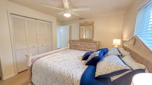 a bedroom with a bed with a ceiling fan and a dresser at Paradise Naples Pool House in Naples