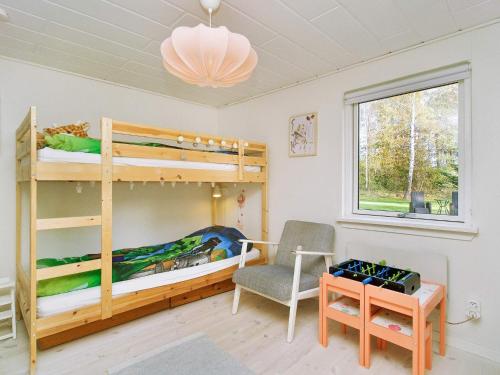 ein Schlafzimmer mit Etagenbetten, einem Stuhl und einem Schreibtisch in der Unterkunft Holiday home Højby III in Højby