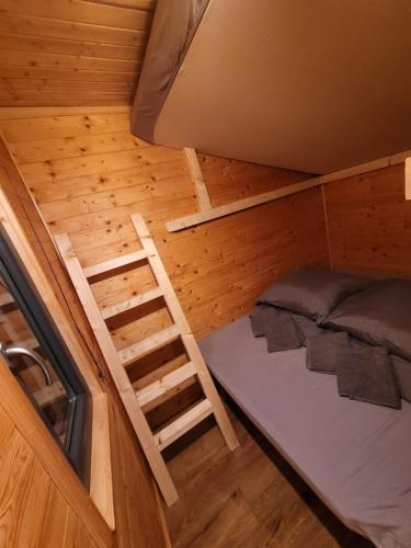 a room with a bunk bed and a ladder at NEU Luxuriöses Tinyhaus Ferienhaus FREYR einmalig in Lübbenau in Klein Klessow