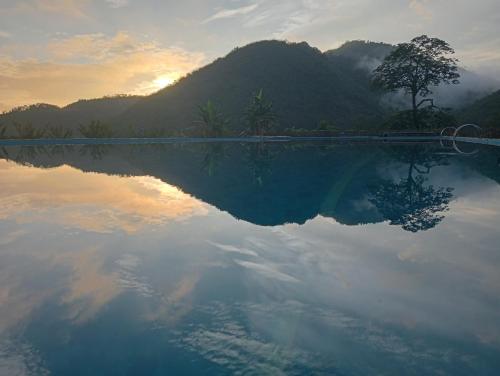 a pool of water with a mountain in the background at La Bằng Homestay in Lá Cam