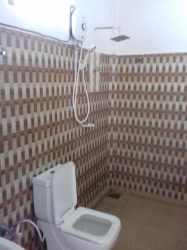 a bathroom with a toilet and a shower at New Golden Bay Resort Weligama in Weligama