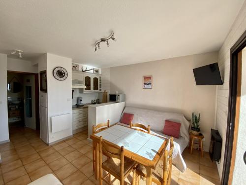 un salon avec une table et une cuisine dans l'établissement Les Angles - Appartement cosy T2 - 6 personnes avec parking et véranda - FR-1-758-15, aux Angles