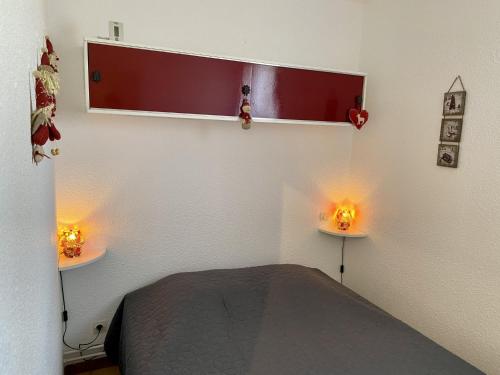 - une chambre avec un lit et deux lumières sur le mur dans l'établissement Les Angles - Appartement cosy T2 - 6 personnes avec parking et véranda - FR-1-758-15, aux Angles