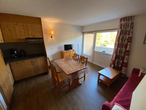 un salon avec une table et une cuisine avec une fenêtre dans l'établissement Charmant appartement à Autrans, 4 pers, 34m², balcon, proche pistes et centre village - FR-1-737-76, à Autrans