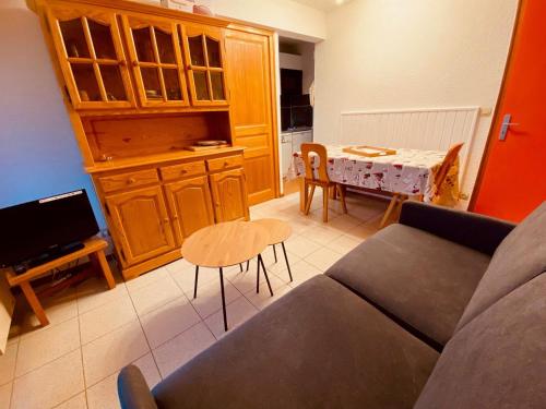 un salon avec un canapé et une table dans l'établissement Appartement cosy avec terrasse, parking et vue montagne à La Clusaz - FR-1-459-220, à La Clusaz