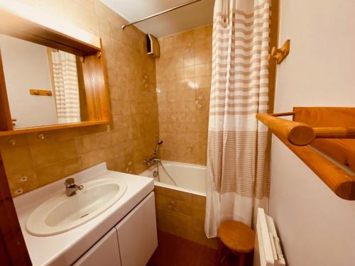 une salle de bain avec un lavabo et une baignoire dans l'établissement Appartement cosy avec terrasse, parking et vue montagne à La Clusaz - FR-1-459-220, à La Clusaz