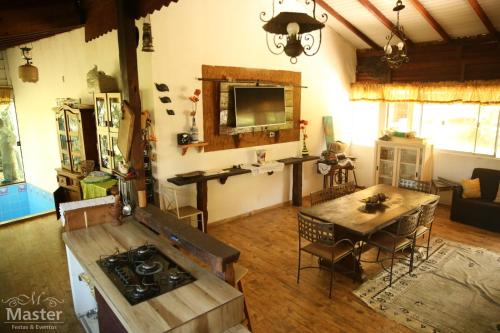 ein Wohnzimmer mit einem Herd und einem Tisch in der Unterkunft Pousada nascente das aguas in Paranaguá