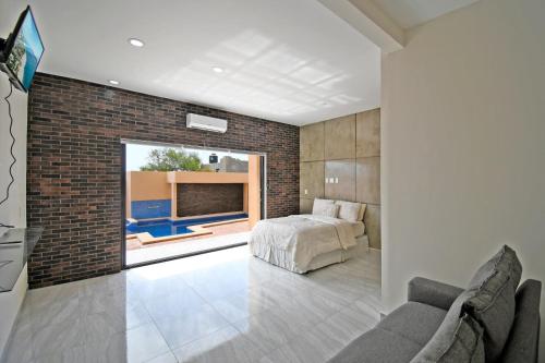- une chambre avec un lit et un mur en briques dans l'établissement Stella Maris, à El Sargento