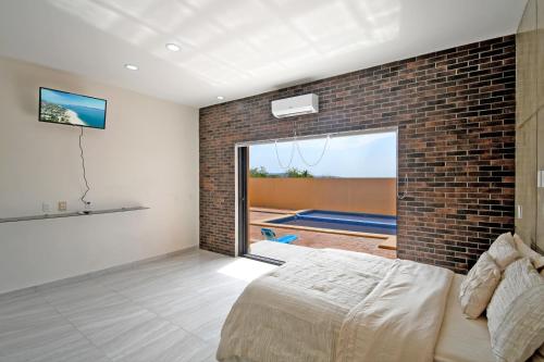 Schlafzimmer mit Ziegelwand und Bett in der Unterkunft Stella Maris in El Sargento