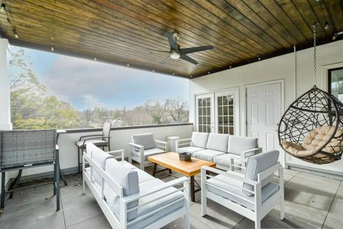 a patio with white chairs and a wooden ceiling at Modern rooftop home in Midtown in Atlanta