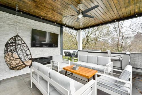 a patio with couches and a table and a tv at Modern rooftop home in Midtown in Atlanta