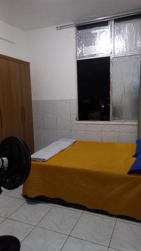a bedroom with a yellow bed and a window at Apartamento 1 Quarto No Centro para até 2 pessoas in Salvador