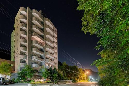 a tall apartment building next to a street at night at MolinHotels302アクティビティを満喫できる札幌定山渓 天然温泉付ホテル-1L1Room Q-Bed2&S-2 4persons in Jozankei