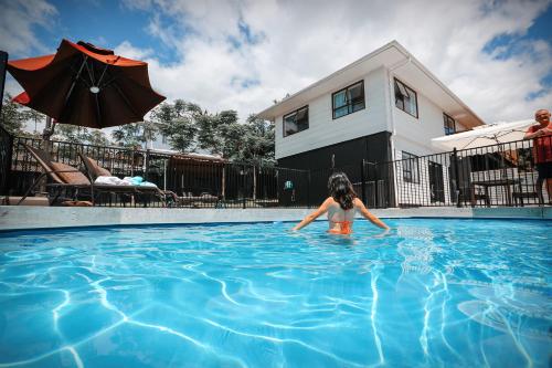 Una joven está en una piscina en Swimming Pool Holiday Villa, en Auckland