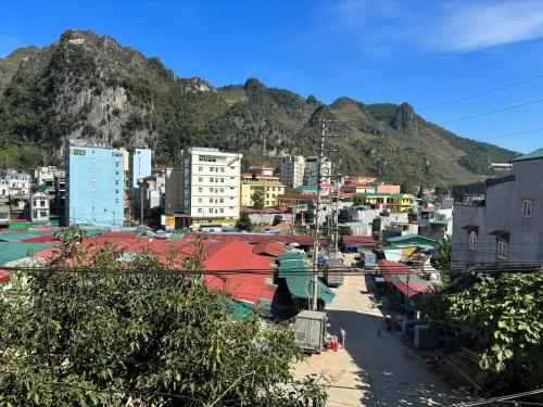 eine Stadt mit Gebäuden und einem Berg im Hintergrund in der Unterkunft Nhà nghỉ Ngọc Khánh in Dồng Văn