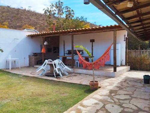 a patio with a table and chairs in a backyard at HOSTEL DA LAPINHA in Santana do Riacho