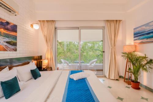 a bedroom with a large white bed with blue pillows at HideAway 2BHK Duplex Villa, North Goa (STU) in Mapusa