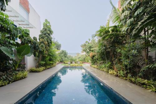 a pool in the middle of a building with trees at HideAway 2BHK Duplex Villa, North Goa (STU) in Mapusa