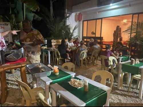 a group of people sitting at tables in a restaurant at Fumiko Rina Acop in San Juan